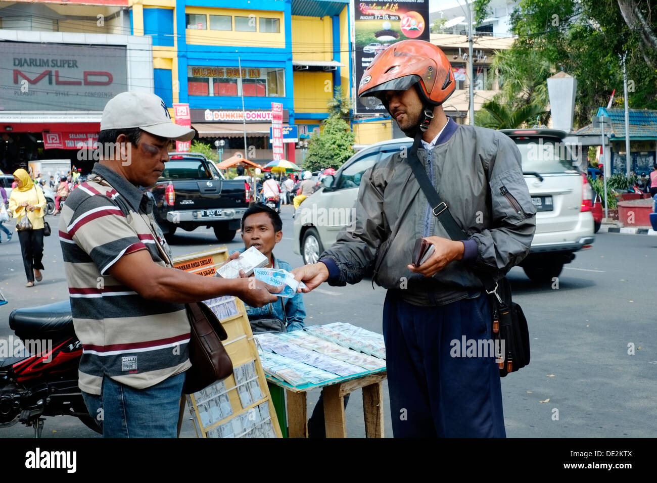 lokale Mann Kauf kleiner Stückelung Rupiah Anmerkungen zu verschenken für Kinder während der Idul Fitri Urlaub Indonesien Stockfoto