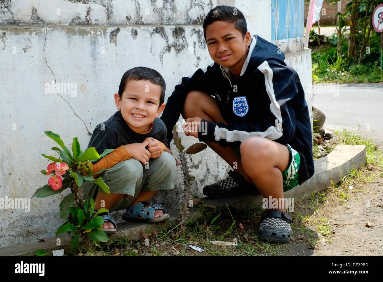 zwei junge Schritt Brüder saßen am Straßenrand in ihrem Dorf in Java Indonesien Stockfoto