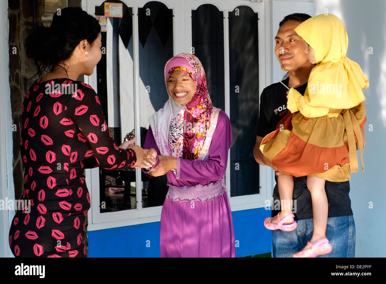einheimische Frau Gruß an ihre Nachbarn, die traditionellen Feiertagen Idul Fitri besuchen Stockfoto