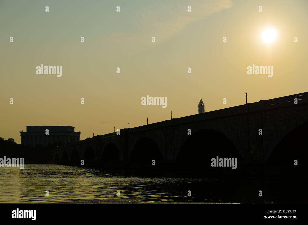 Die Sonne steigt über Memorial Bridge, gesehen aus Arlington, VA, Seite, wie es erstreckt sich über den Potomac. Das Lincoln Memorial ist auf der anderen Seite auf der linken Seite des Rahmens Silhouette. Stockfoto