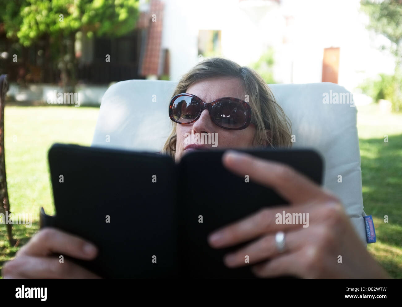 Frau liest ein Buch auf ihrem e-reader Stockfoto