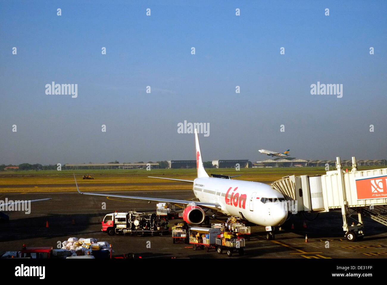 Lion air Boeing 737-900er auf seinem Ständer mit einem Merpati Flugzeug abheben hinter in Surabaya Juanda Flughafen Java Indonesien Stockfoto