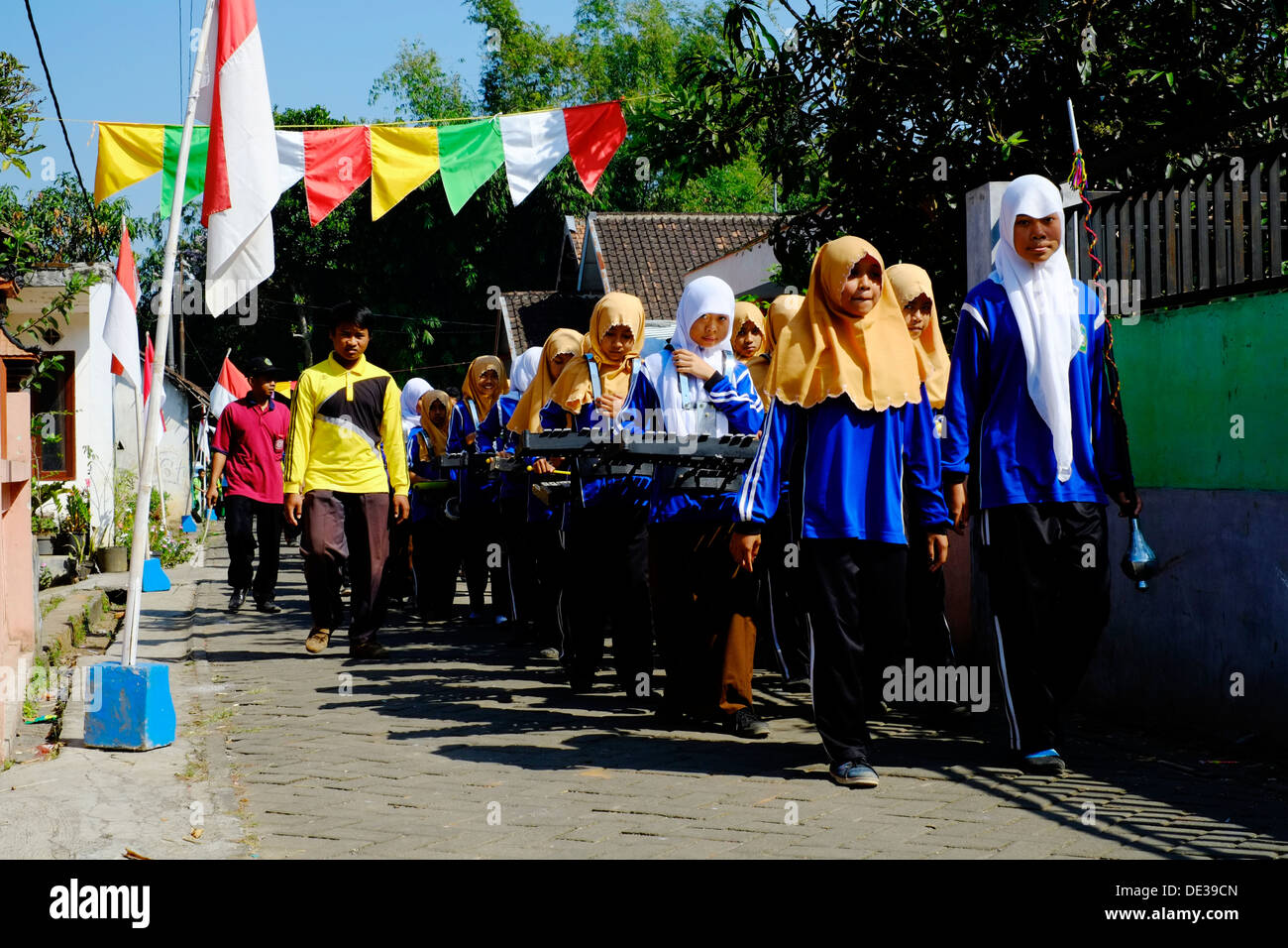 große Gruppe von Schulkindern an einem Freiheitstag für Indonesien marschieren durch ein kleines Dorf in java Stockfoto