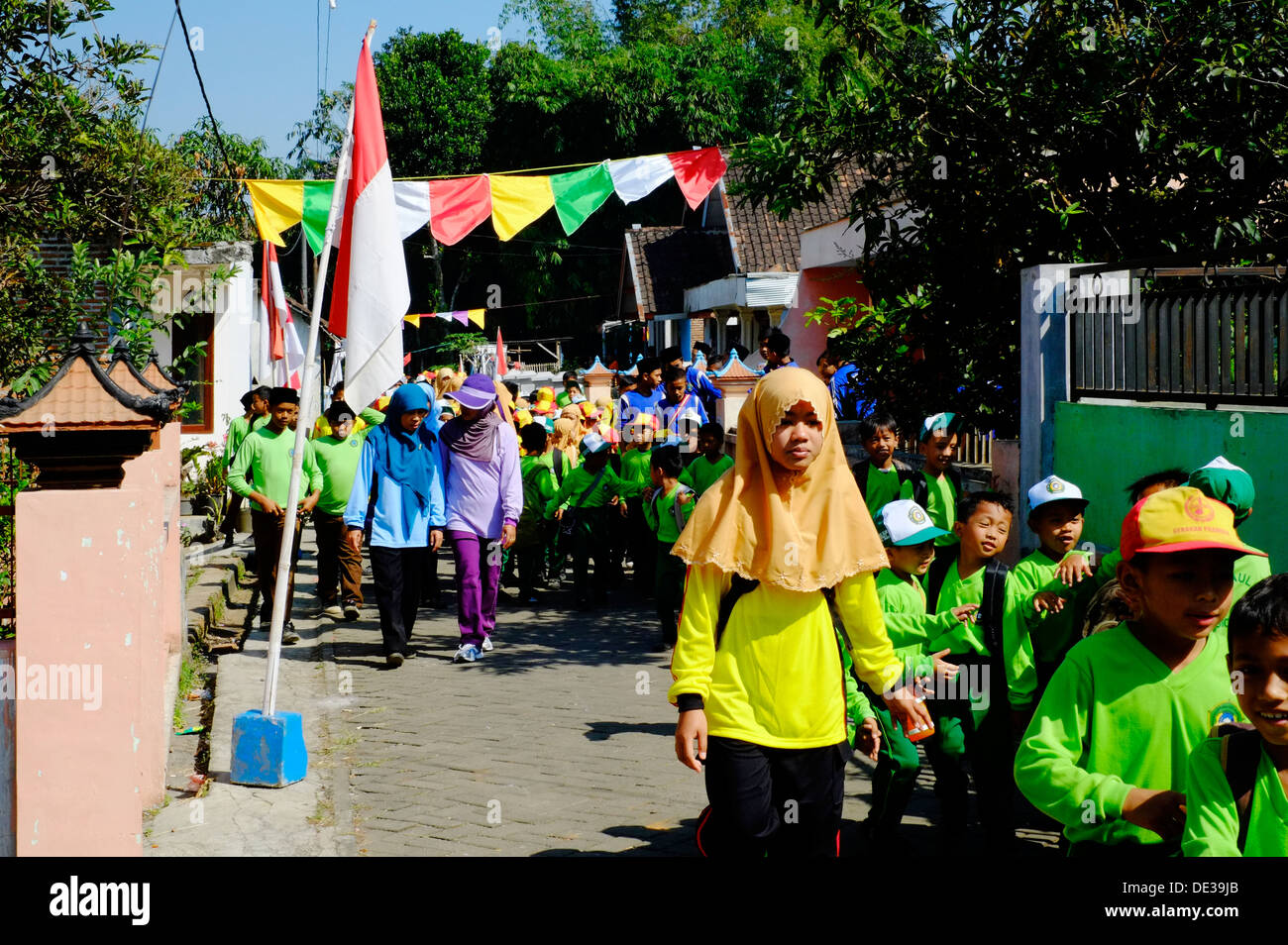 große Gruppe von Schulkindern an einem Freiheitstag für Indonesien marschieren durch ein kleines Dorf in java Stockfoto