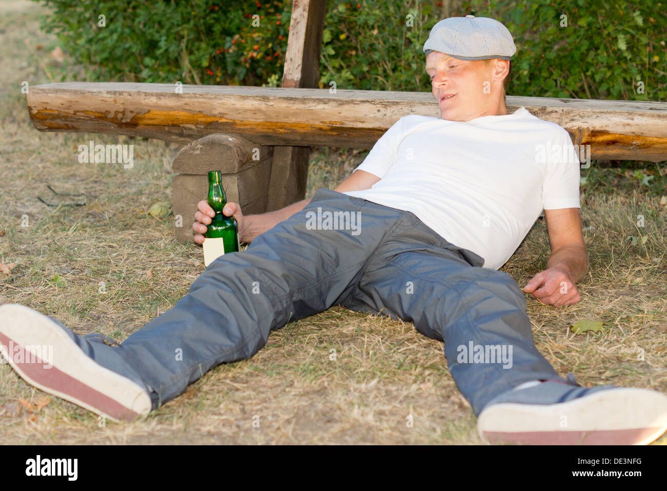 Süchtig Mann liegt auf dem Boden erleben Lethargie nach übermäßiger Alkoholkonsum Stockfoto