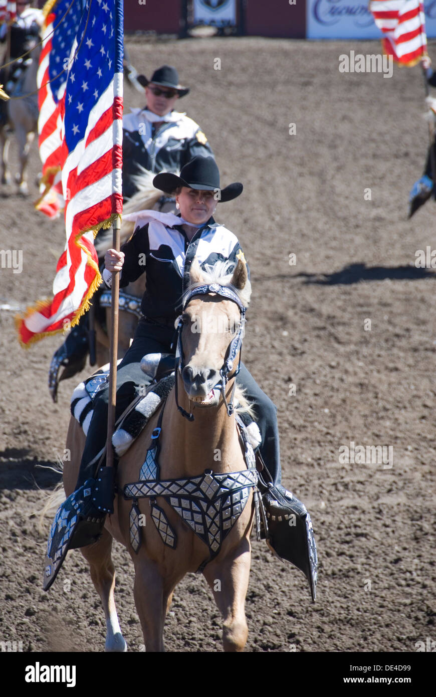 Cowgirl Trägerin auf dem Pferderücken mit amerikanischen Stars und Stripes Flaggen, Ellensburg Rodeo Eröffnungsfeier, Washington, WA, USA Stockfoto