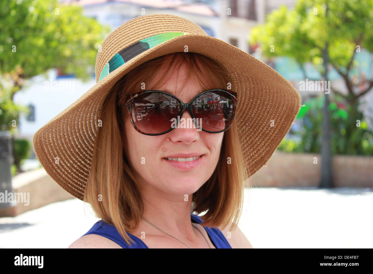 Schönen lächelnden Dame in sonniger Platz mit Hut und Sonnenbrille Stockfoto