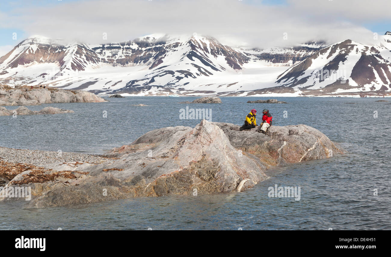 Paar auf Felsen, Hornsund, Spitzbergen-Island, Spitzbergen, Norwegen Stockfoto