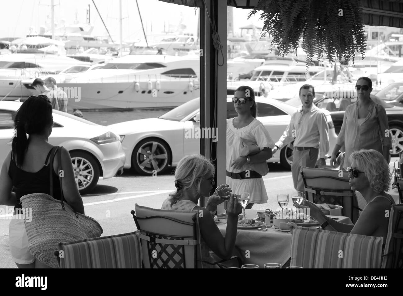 Blick über Café-Restaurant in Richtung Hafen in der sonnigen mediterranen Stadt Stockfoto