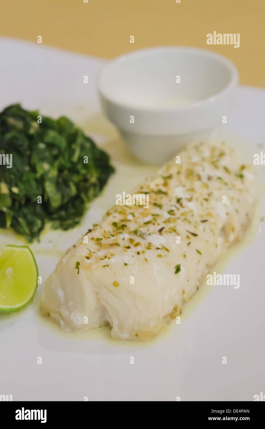 Der Sesoning Fisch Filet mit Spinat auf weißen Teller Stockfoto