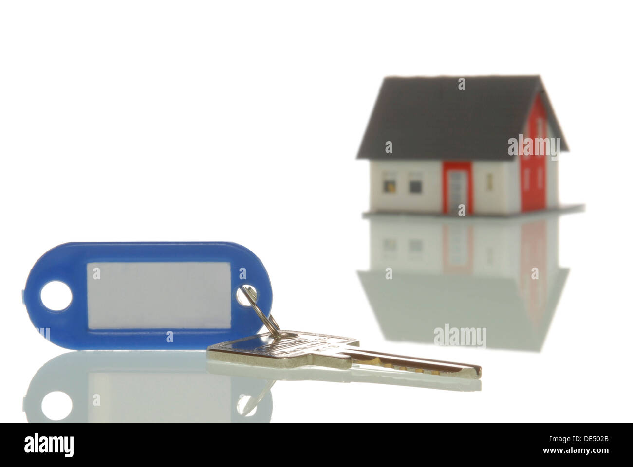 Schlüssel vor ein Miniaturhaus, symbolisches Bild für Immobilienmarkt liegen Stockfoto