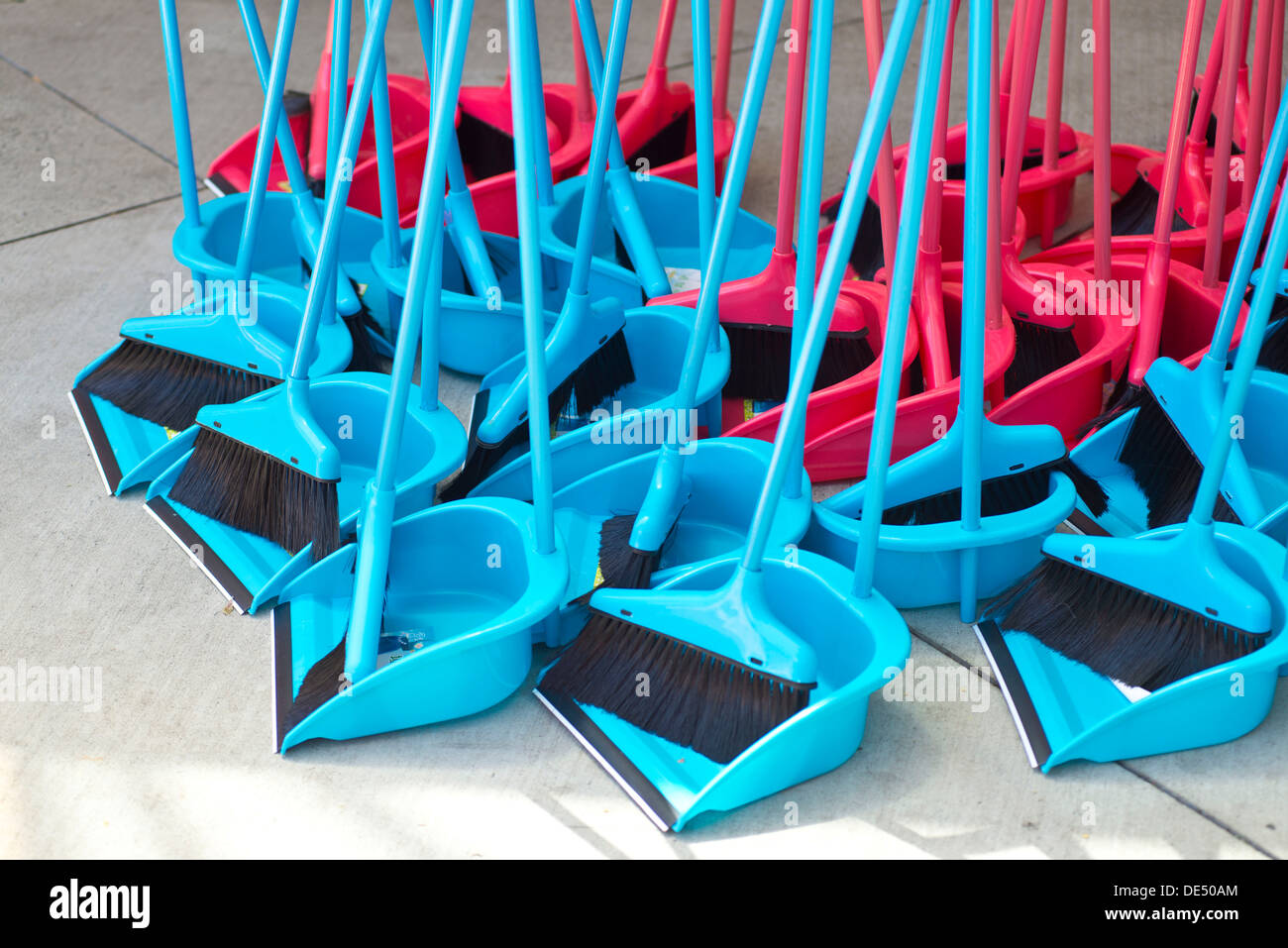 Blaue und rote Besen mit Schaufel Stockfoto