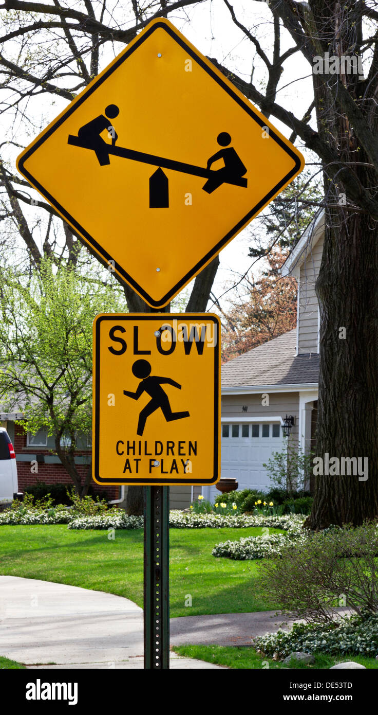 Kinder spielen Straßenschild in Nachbarschaft warnt langsam fahren; zeigt Kinder sah und laufenden Kind sehen. Stockfoto