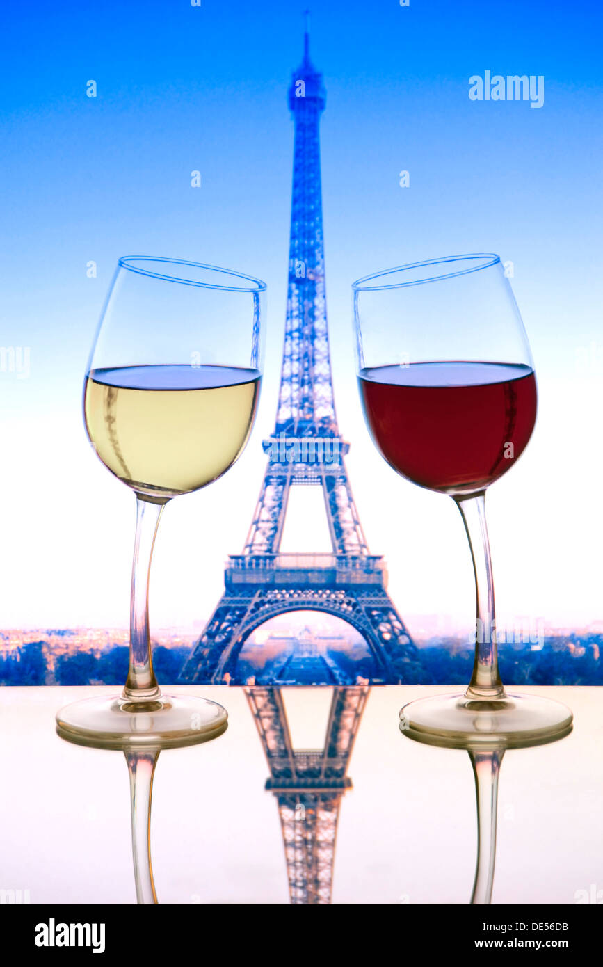 PARIS WINE EIFFEL FUN VIEW 'Cheers' mit rot-weißen Weingläsern, die sich auf dem Café-Tisch mit Eiffelturm hinter Paris France aneinander lehnen. Stockfoto