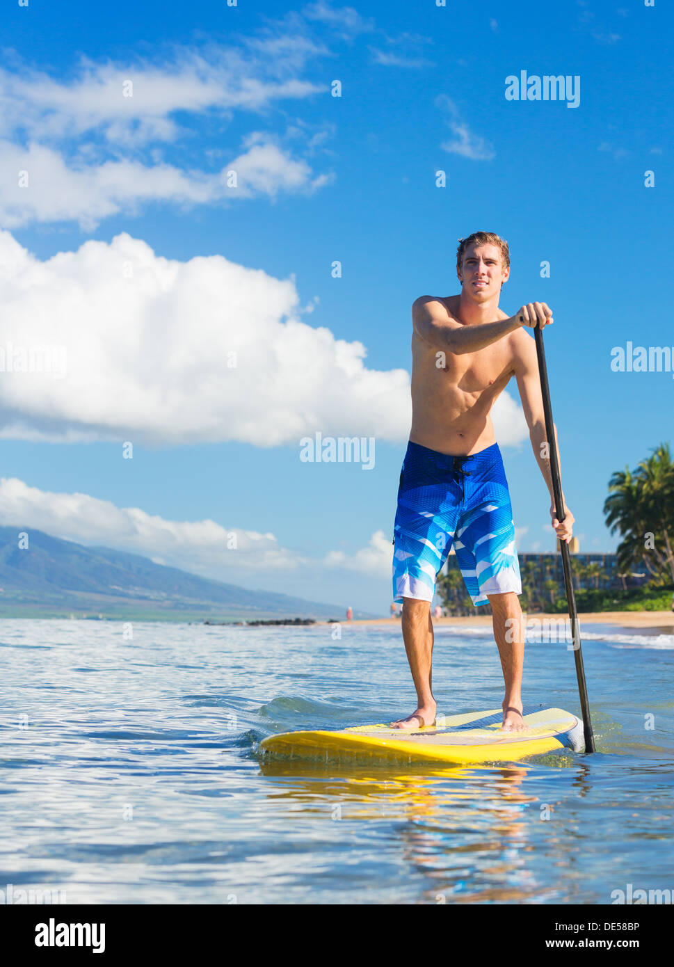 Junge attraktive Mann am Stand Up Paddle Board, SUP, in den blauen Gewässern vor Hawaii, Active Life-Konzept Stockfoto