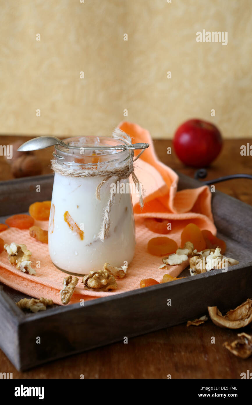 Joghurt und ein Glas mit Nüssen und getrockneten Aprikosen, Essen Nahaufnahme Stockfoto