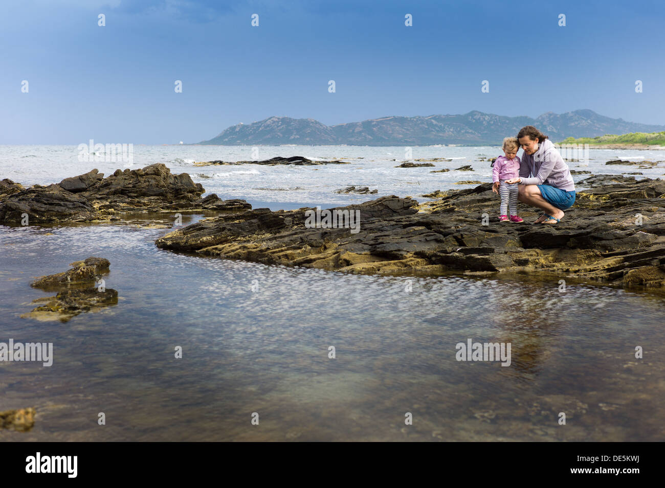 Eine Mutter mit Kind auf dem Steinkueste in Sardinien Stockfoto