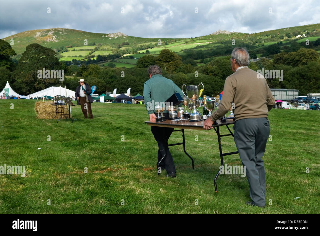 Silberne Trophäentassen werden auf einem Tischgestell getragen, um die Preisverleihung bei der jährlichen Dorfschau vorzubereiten. Widecombe Fair, Widecombe im Moor Dartmoor Devon, England 2013 UK 2010er HOMER SYKES Stockfoto