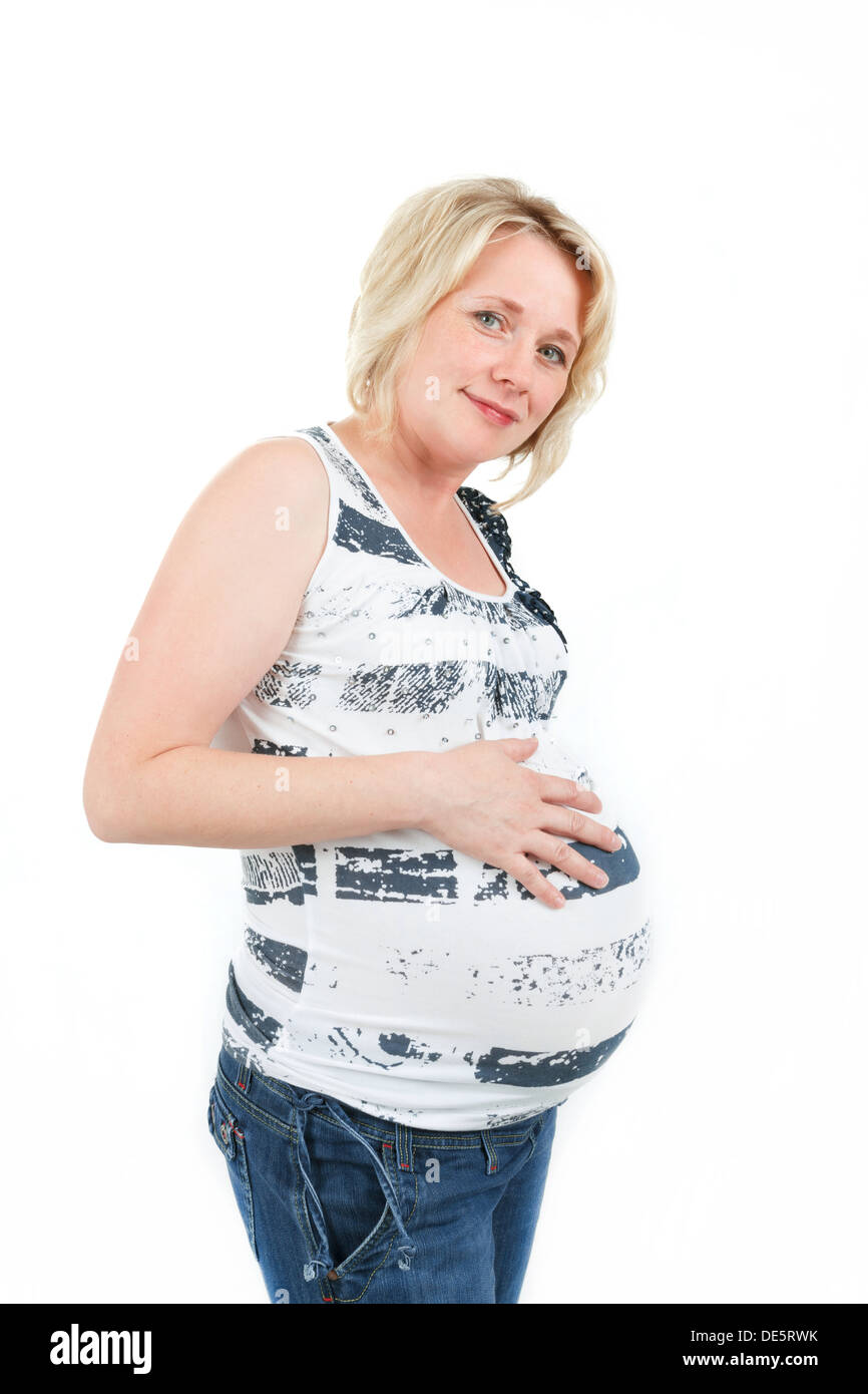 schönes Lächeln schwanger Frau zärtlich mit ihrem Bauch isoliert auf weißem Hintergrund Stockfoto