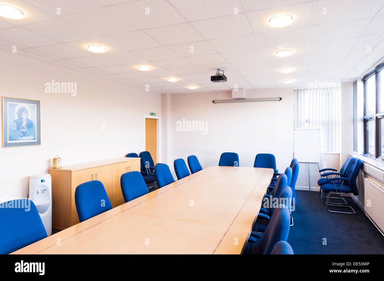 Ein typisches Sitzungssaal / Tagungsraum / Konferenzraum mit einer Wand montiert, Bildschirm und Deckenbeamer montiert. Stockfoto