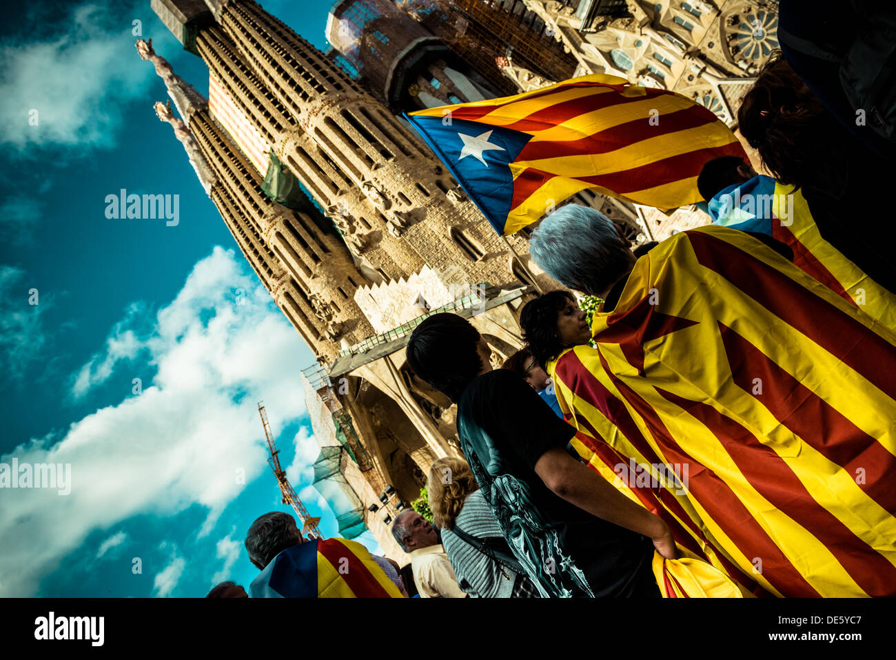 Barcelona, Spanien. 11. September 2013: Blue "Estelada" Fahnen, symbol für die unabhängige "Paisos Catalans" (katalanische Länder) eine eingewickelt um Demonstranten vor Barcelonas Sagrada Familia während der "Via Catalana" am Nationalfeiertag Kataloniens © Matthi/Alamy Live-Nachrichten Stockfoto