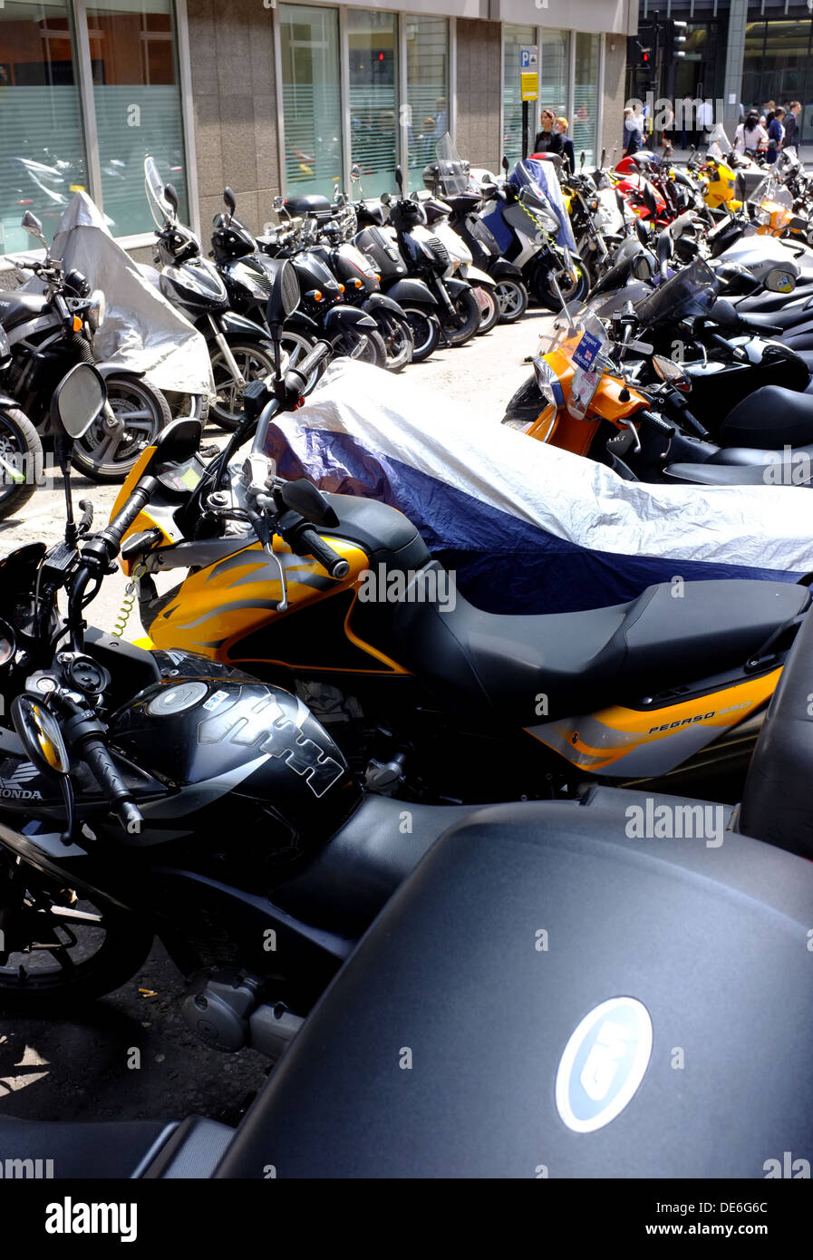 Pendler-Motorräder und Mopeds, die fest in der City of London geparkt, wie Arbeiter der City-Maut vermeiden Stockfoto