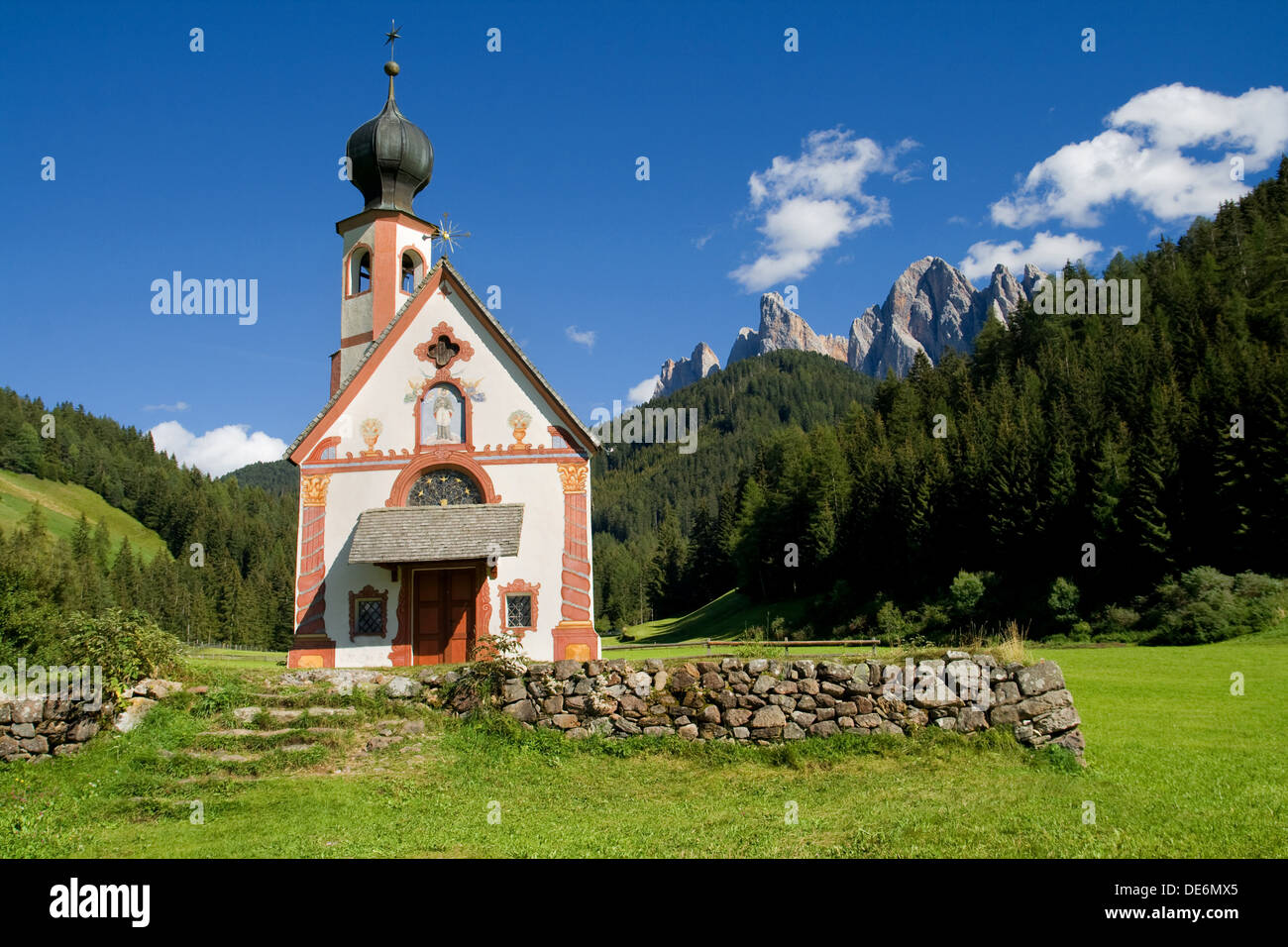 Kirche von St. Johann in Ranui im Tal von Villnoss mit den Geisler-Bergen im Hintergrund, Dolomiten, Italien. Stockfoto