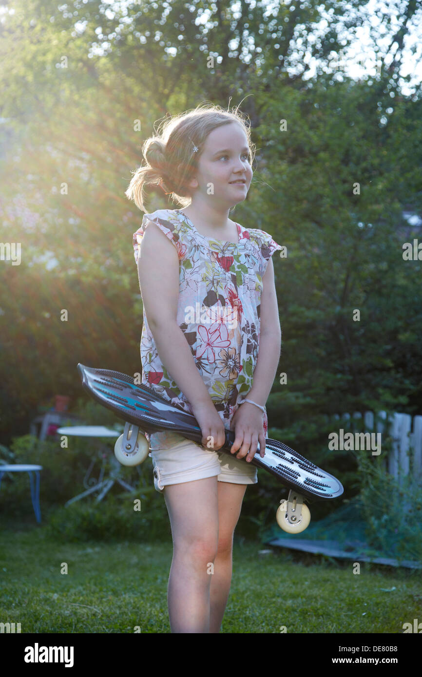 Deutschland, Mädchen halten Waveboard und wegsehen Stockfoto