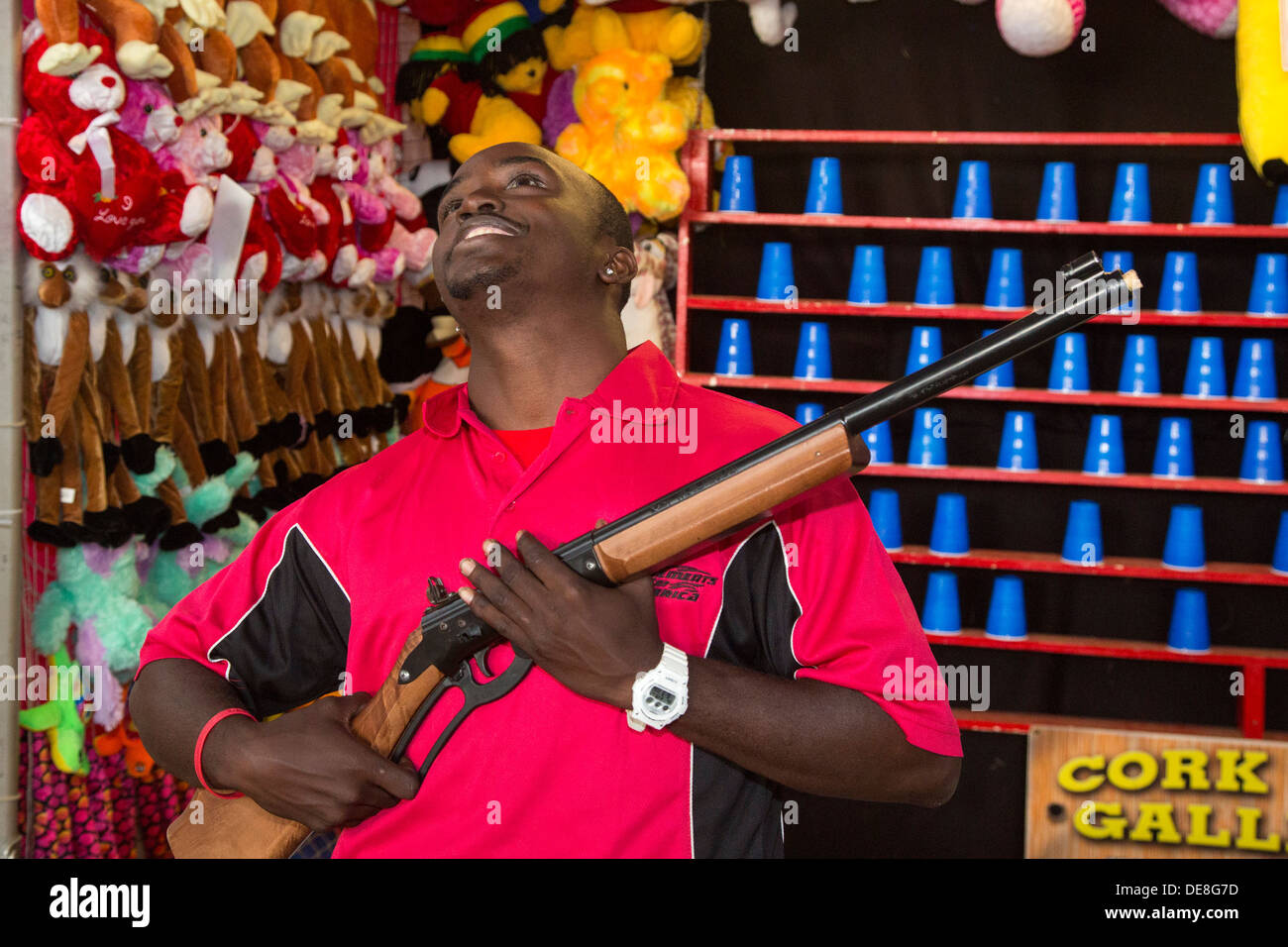 Chatham, New York - ein Karneval Mitarbeiter schlägt eine Pose für einen Fotografen bei einem shooting Spiel im Columbia County Fair. Stockfoto