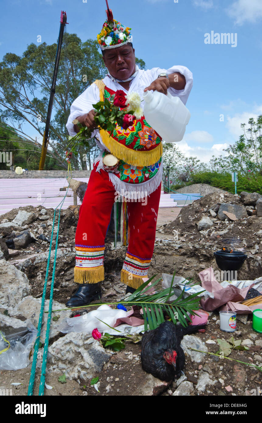 Volador gießt Wasser über die rituellen Opfergaben während der rituellen Vorbereitung der Voladores in Mexiko Stockfoto