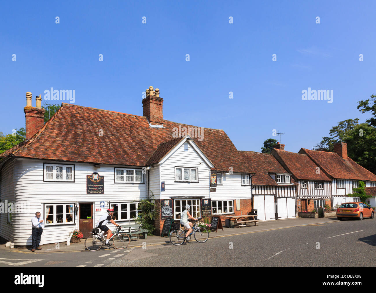 Menschen Radfahrer außerhalb des Chequers Inn alten 14. Jahrhundert Coaching Inn Pub in malerischen englischen Dorf. The Street Smarden Kent England Großbritannien Stockfoto