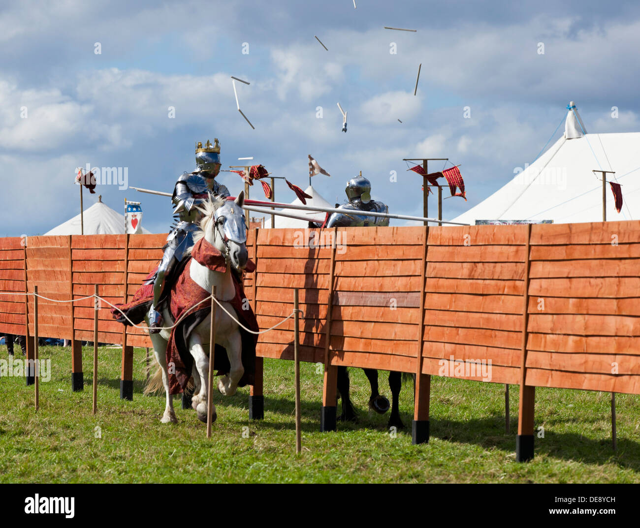 Zwei Ritter in mittelalterlichen Rüstungen kämpfen um Runde auf dem Pferderücken mit Lanzen England UK GB EU Europa Stockfoto