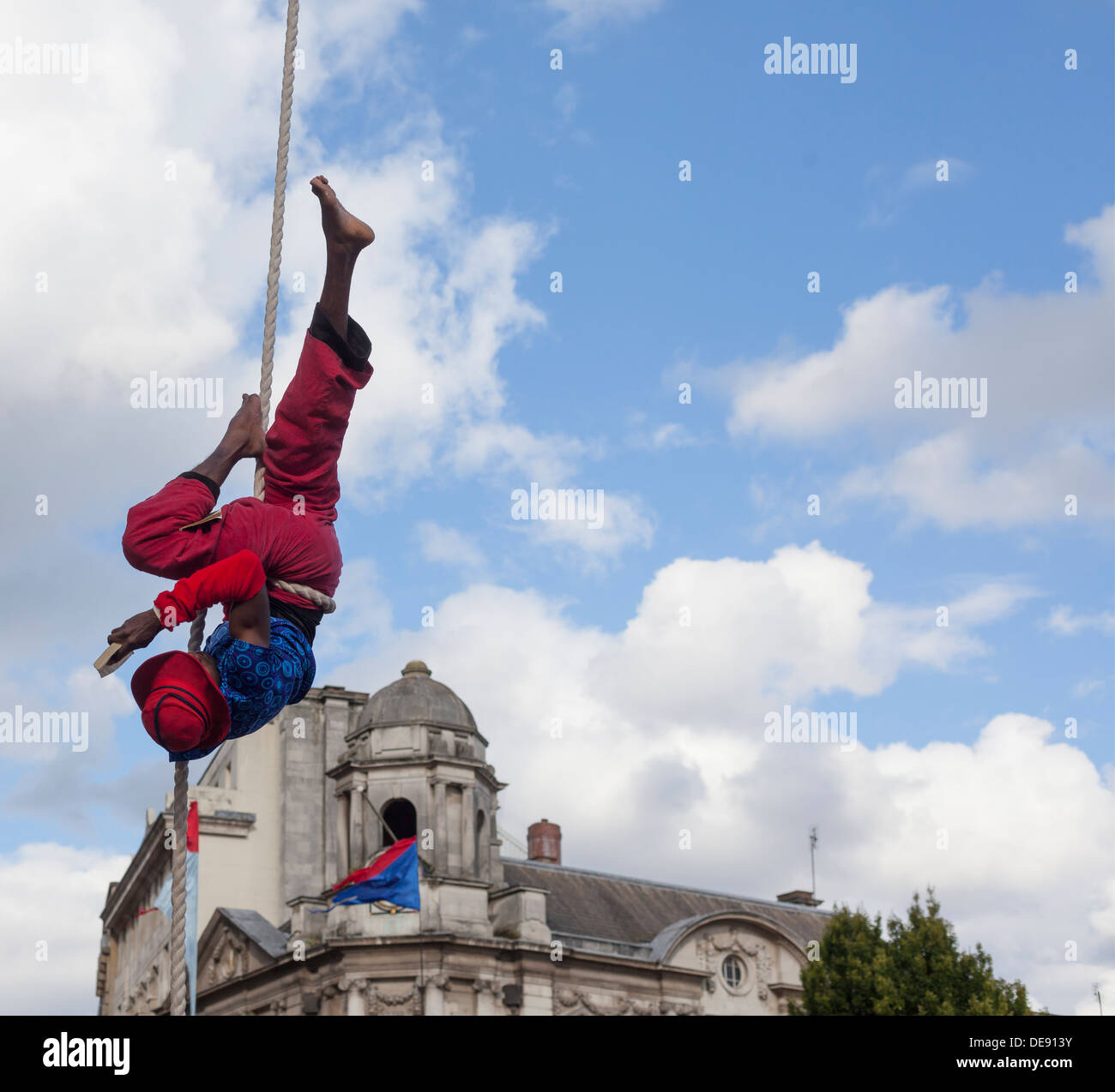 Acrobat aus No Fit Staatszirkus Gruppe ein Buch als Bestandteil der 4SquaresWeekender Birmingham an einem Seil aufgehängt. Stockfoto