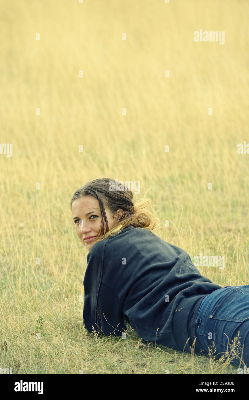 Junge schöne Frau im Grass liegen Stockfoto