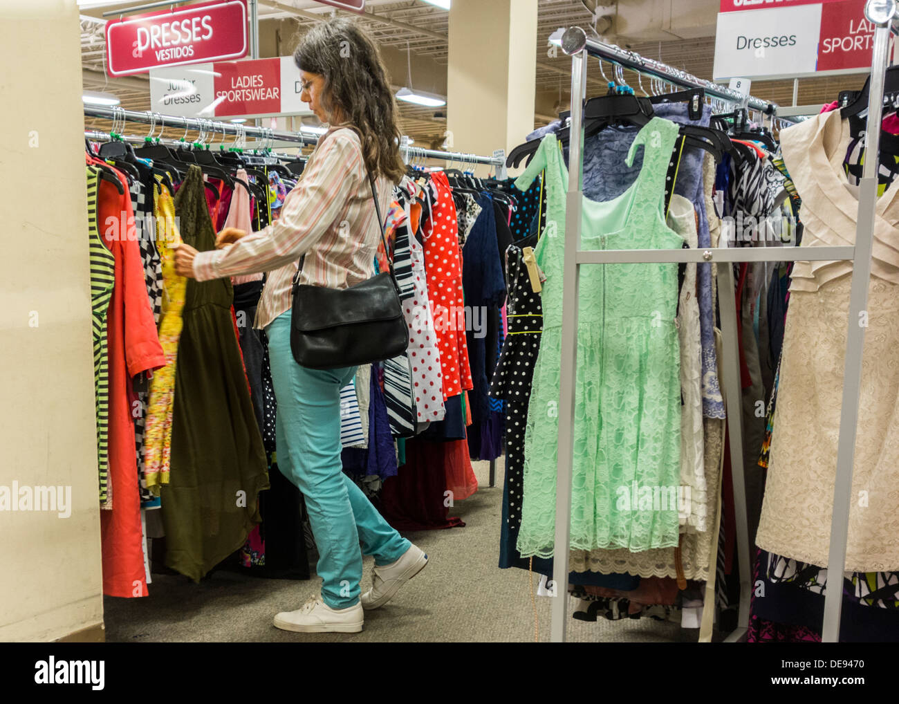 Eine Frau sucht ein Rack der Kleider auf den Verkauf in einem Rabatt Kaufhaus in Oklahoma City, Oklahoma City, Oklahoma, USA. Stockfoto