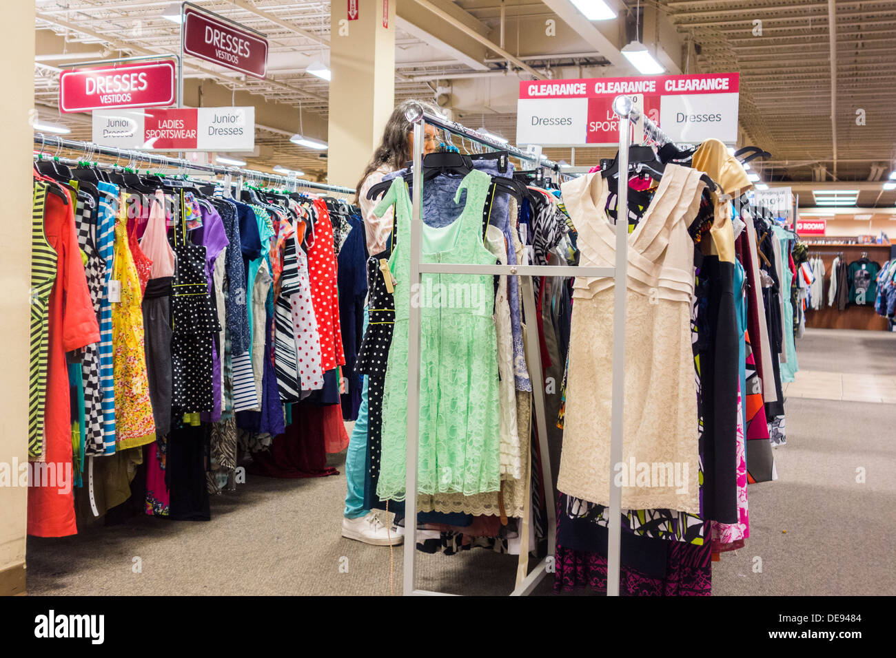 Eine Frau durchsucht eine Rack mit Kleider auf Verkauf in einem Discount-Kaufhaus in Oklahoma City, Oklahoma, USA. Stockfoto