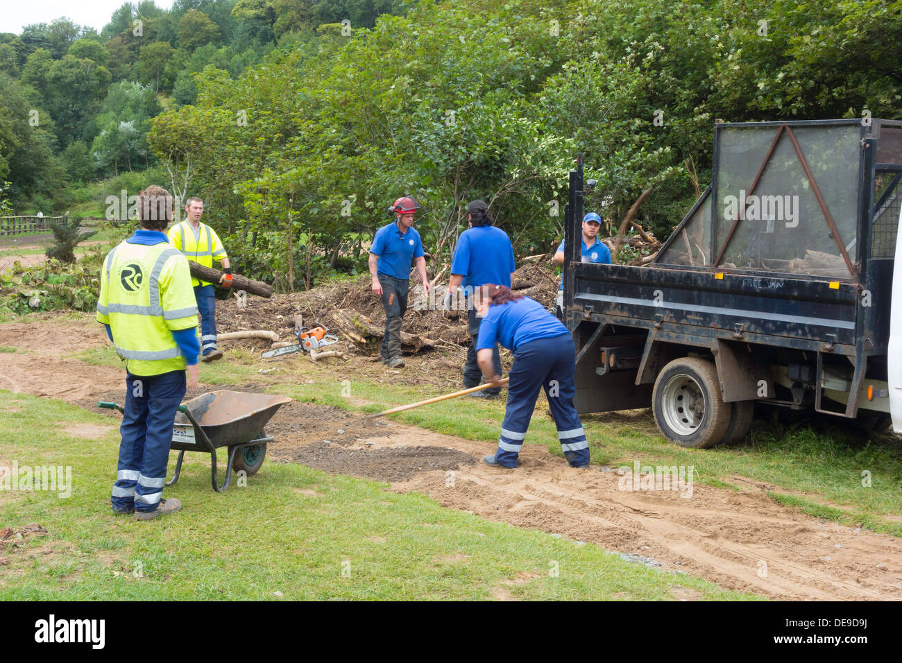 Lokale Behörde Arbeiter clearing umgestürzte Bäume und Reparatur beschädigt Pfade in einem Park nach einem schweren Hochwasser Stockfoto