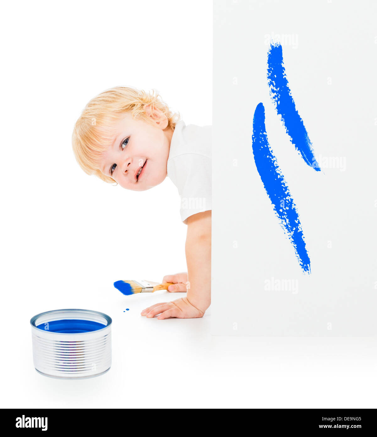 Baby Boy mit Pinsel auf allen Vieren hinter gemalten weißen Wand Stockfoto