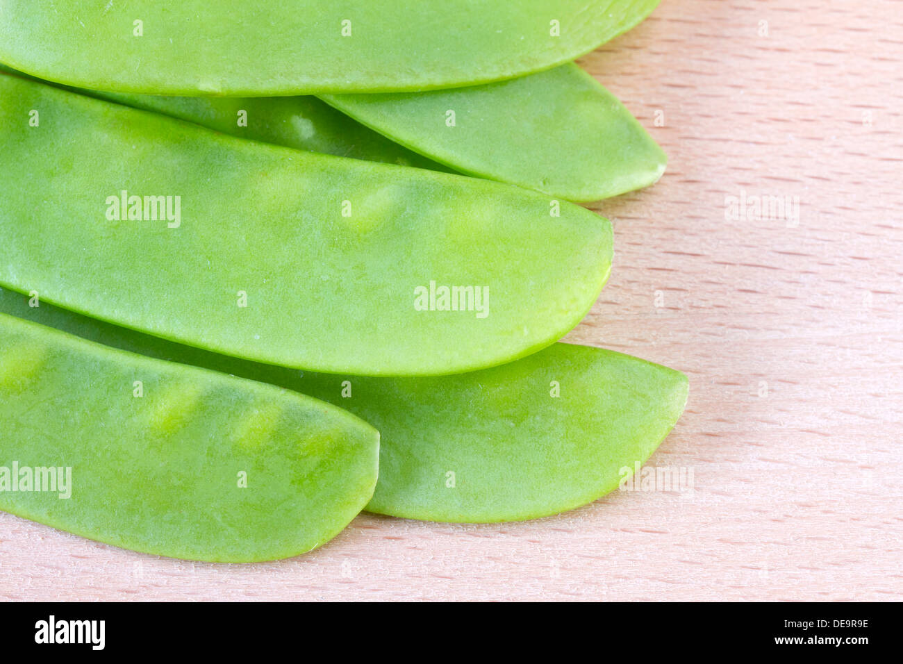 Zuckererbsen auf Schneidbrett aus Holz Stockfoto