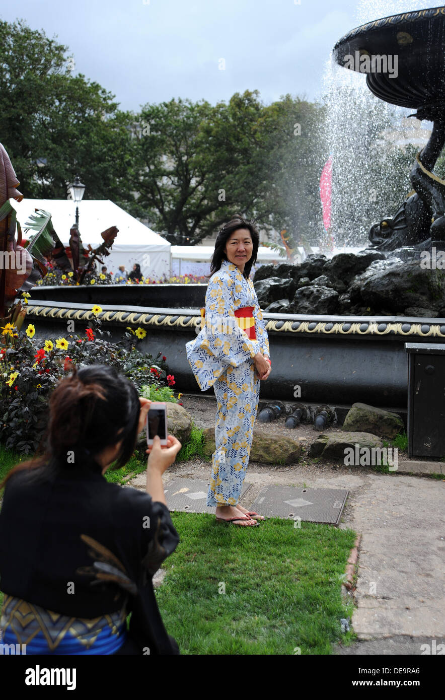 Eine Frau in einem traditionellen japanischen Kimono gekleidet hat ihr Foto aufgenommen am Brighton Japan 2013 Festival, das im alten Steine Garten stattfindet Stockfoto