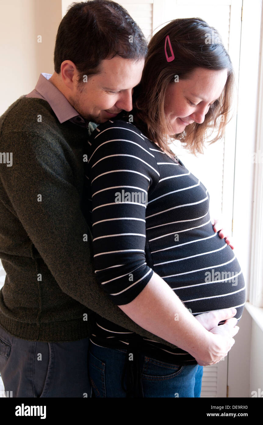 Schwangere Frau und Partner mit ihren Händen um ihr ungeborenes Baby-Bauch Stockfoto