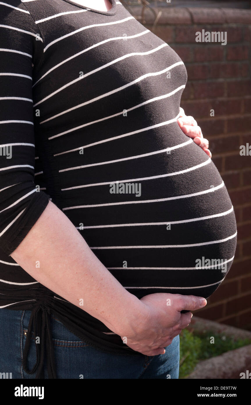 Aufnahme einer schwangeren Frau mit ihren Händen um ihr ungeborenes Baby-Bauch beschnitten Stockfoto