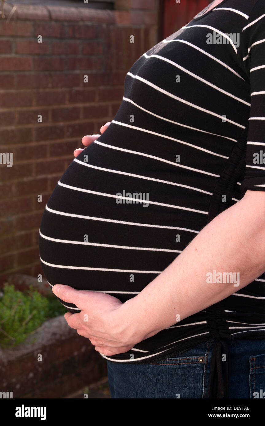 Aufnahme einer schwangeren Frau mit ihren Händen um ihr ungeborenes Baby-Bauch beschnitten Stockfoto