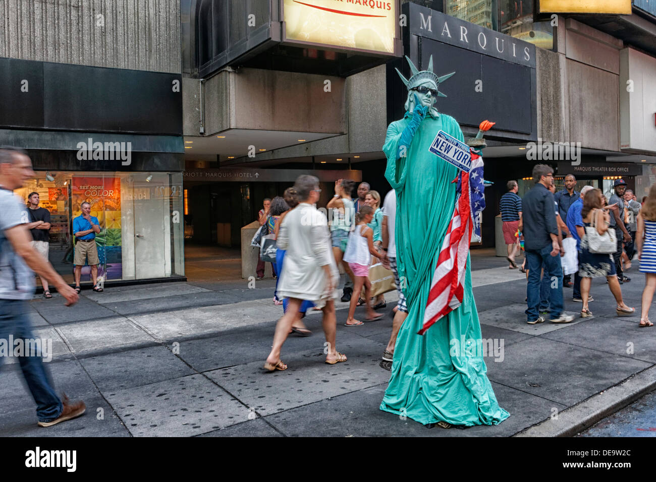 New York, MA - 11. Juli 2013: ein Darsteller gekleidet, wie Lady Liberty gehen auf Stelzen für Bild im Times Square bringt. Stockfoto