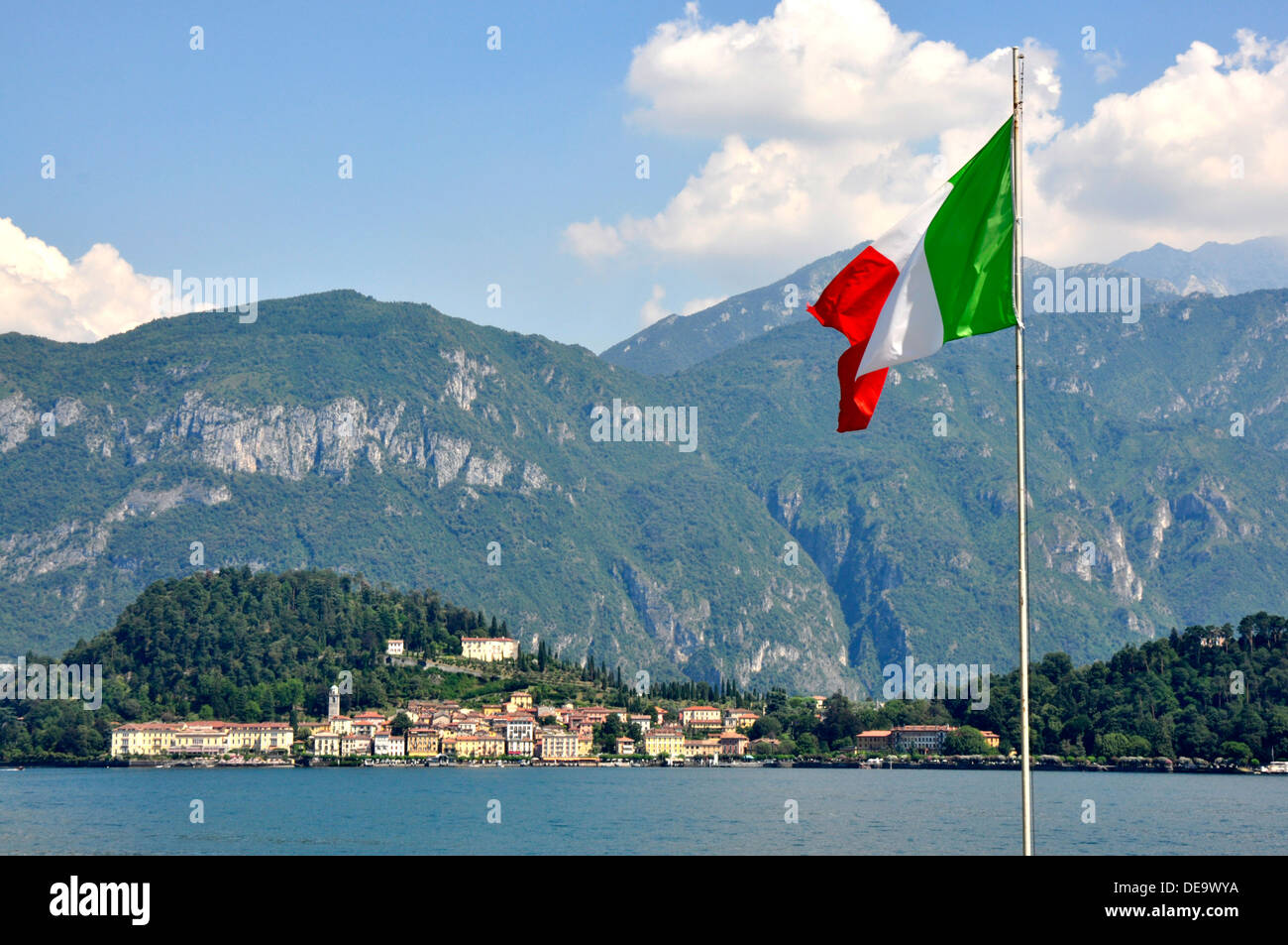 Italien - Comer See - italienische Nationalflagge - Bellagio Stadt über den See - umgeben von bewaldeten Hängen und Bergen - Sommer Stockfoto