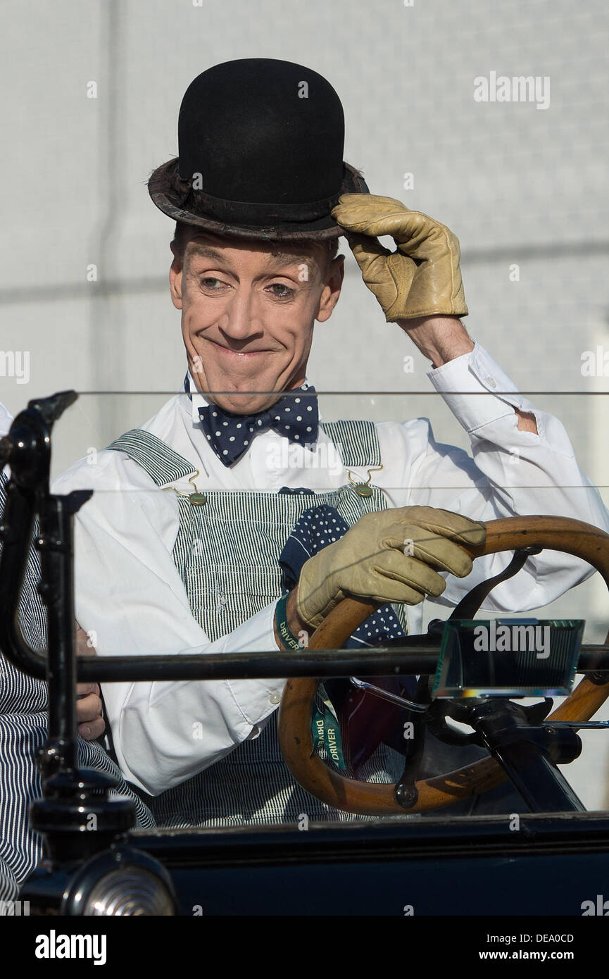 Chichester, West Sussex, UK. 14. September 2013. Beim Goodwood Revival. Goodwood-Rennstrecke, West Sussex - Samstag, den 14. September. Ein Schauspieler verkleidet als Stan Laurel Oldtimer fährt, während seine Marke Melone an die Zuschauer zu erhöhen. Bildnachweis: MeonStock/Alamy Live-Nachrichten Stockfoto