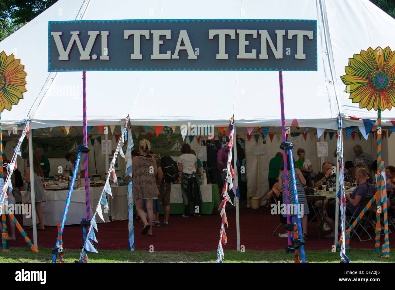 Frauen Institut Wi Teezelt mit einem großen Schild, bunte Girlanden und Menschen im Inneren beim Musikfestival Bestival Camp Stockfoto