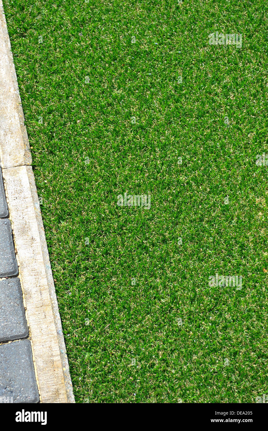 Ein Teil der grünen Kunstrasen und steinerne Einfassung von oben gesehen Stockfoto