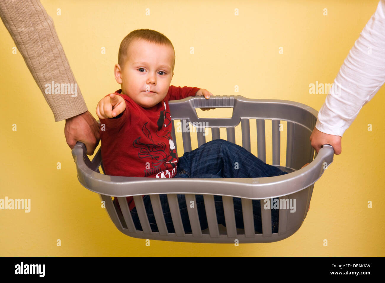 Junge, 2 Jahre, durchgeführt in einen Wäschekorb Stockfoto