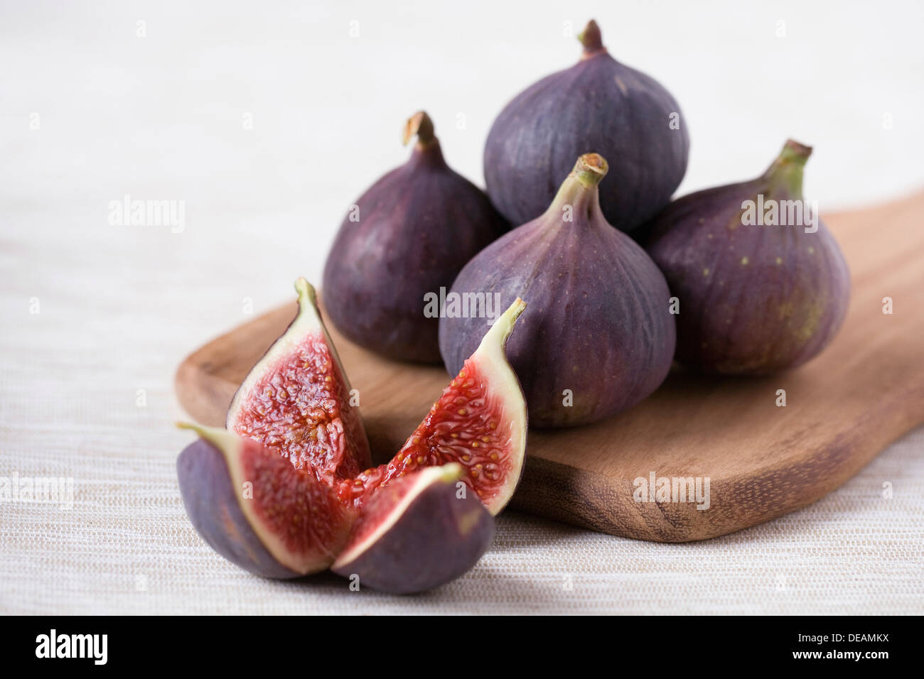 Ficus Carica. Fünf schwarze Bursa Feigen auf einem Holzbrett. Stockfoto